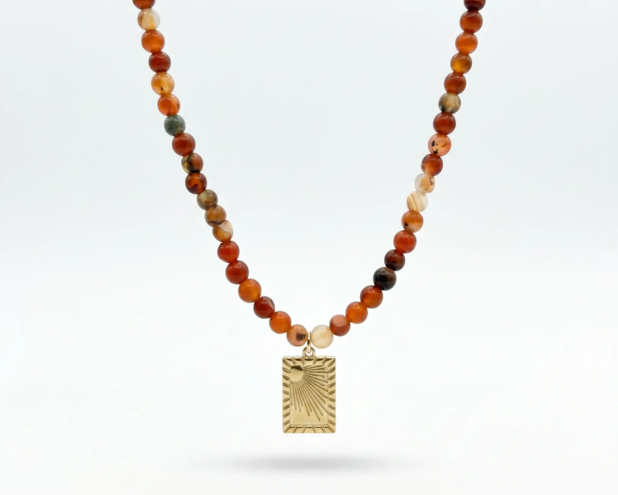 Necklace with multicolored beads and a gold pendant on a white background