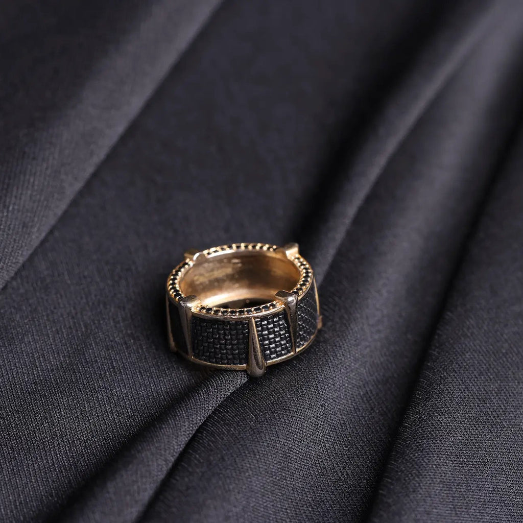 Salitaire Panther Spike Ring in gold tone with black CZ micro pave segmented panels and spiked beaded edge on dark fabric